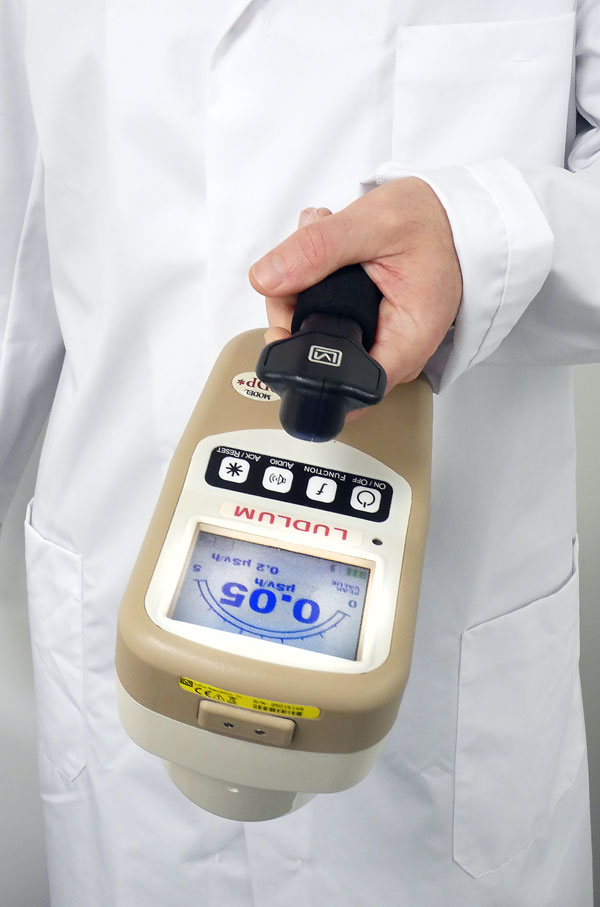 Person in lab coat holding the model 9DP from Ludlum